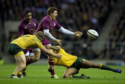 England's full back Alex Goode (C) is tackled by Australia's flanker Michael Hooper (L) and fly half Kurtley Beale (R)